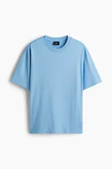 Remera de algodón celeste de corte relajado, con cuello redondo ribeteado y mangas cortas con hombros caídos.