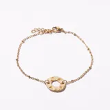 Pulsera dorada con cadena de eslabones y dije circular martillado.