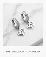 Caravanas tipo argolla de acero con incrustaciones de piedras brillantes y dije colgante en forma de corazón con diseño calado.