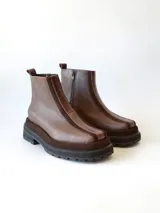 Bota corta de cuero en tonos chocolate, con diseño de paneles texturizados y suela track robusta de goma.