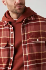 Camisa de franela a cuadros color ladrillo, con bolsillos frontales y corte recto.