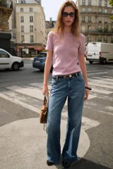 Jersey de punto color rosado claro, con cuello redondo y manga corta. Presenta una textura suave y un acabado ligeramente jaspeado.