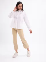 Jean de corte mini flare en color beige, con diseño de tiro medio y largo hasta el tobillo, confeccionado en tejido de algodón con elastano.