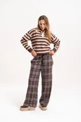 Pantalon de corte amplio y tiro medio con estampado de cuadros en tonos marrones. Cuenta con cintura elastizada con cordón ajustable y bolsillos laterales.
