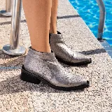 Bota corta de cuero vacuno con acabado metalizado y textura de reptil. Presenta punta fina, cierre lateral interno y taco cuadrado de madera.