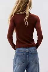 Top de punto suave con cuello alto y mangas largas, de diseño entallado.