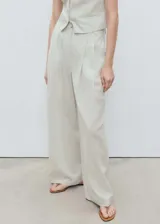 Pantalón de tiro medio con diseño recto y estilo sastrero. Confeccionado en tejido mezcla de algodón y lino con estampado de rayas verticales finas. Cuenta con cierre delantero de cremallera y botón, trabillas para cinturón y bolsillos laterales.