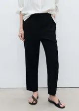 Pantalón fluido de color negro con cintura elástica y cordón ajustable. Presenta diseño recto y bolsillos laterales.