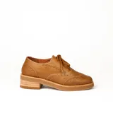 Zapato acordonado estilo oxford de cuero vacuno en color plateado metalizado, con diseño brogue, suela de goma y taco de madera.