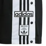 Short deportivo Adidas modelo Adibreak, color negro con franjas laterales blancas y botones a presión decorativos. Presenta el logo de la marca y el diseño clásico de las tres tiras en los costados.