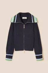 Cárdigan de punto azul marino con cierre frontal de cremallera. Presenta cuello tipo camionero y puños con detalles de rayas en tonos verde y celeste. El tejido tiene una textura acanalada con detalles calados decorativos.