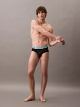 Pack de tres slips negros Calvin Klein con cintura elástica en colores lila, amarillo y celeste, con el logo de la marca.