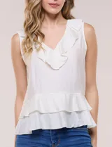 Blusa blanca sin mangas confeccionada en tejido de satén con suave textura arrugada y caída fluida. Cuenta con escote en V con volante en el cuello y ruedo estilo peplum con doble capa de volados superpuestos.