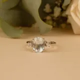 Anillo solitario de oro blanco 18k con una piedra central de aguamarina en corte ovalado y brillantes laterales engarzados.