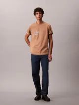 Remera Calvin Klein de manga corta y cuello redondo, color beige, con logo estampado en el pecho.