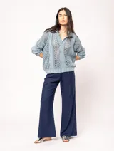 Sweater tejido de algodón color crudo, con cuello polo y escote en V. Diseño con ochos verticales en delantera, espalda y mangas, y punto abierto.