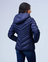 Campera de abrigo verde esmeralda, marca Michael Kors. Diseño acolchado con cierre metálico central, capucha no desmontable con cordón de ajuste y bolsillos verticales delanteros. Incluye bolsa autoportante.