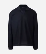 Polo de manga larga color beige claro, confeccionado en tejido texturizado (posiblemente acanalado o waffle). Presenta un cuello polo con escote profundo en V sin botones.