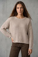 Sweater de punto texturado en color bordó con destellos de lurex, de corte holgado, cuello redondo y mangas largas.