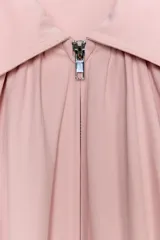 Bomber color rosado con cuello solapa, mangas largas tipo globo y bajo asimétrico. Cierre frontal con cremallera metálica.