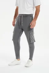 Babucha de estilo cargo en color gris, con cintura elástica ajustable mediante cordón, bolsillos laterales con solapa y puños elásticos en los tobillos.