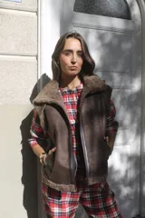 Chaleco estilo bomber de cuero genuino color marrón, con interior de piel sintética y cierre frontal. Presenta cuello solapa y bolsillos laterales.