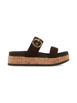Sandalias de plataforma estilo flatform con dos tiras anchas en el empeine, confeccionadas en material marrón. La tira superior cuenta con una hebilla metálica grande en tono dorado y ojales decorativos. La plataforma posee una textura símil corcho.