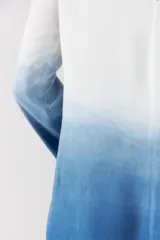 Vestido corto con diseño degradado en tonos blanco y azul, de corte recto, manga larga y cuello redondo.