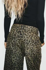 Jeans de tiro medio estilo baggy con estampado animal print, trabillas para cinto y diseño de cinco bolsillos. Cuenta con cierre frontal con cremallera y botón metálico.