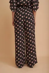 Conjunto de pantalón palazzo y blusa de mangas cortas, color negro con estampado de estrellas rosas.