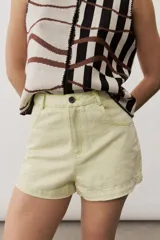Short gris claro de tiro alto con costuras pespunteadas en contraste y bolsillos traseros amplios. Presenta una etiqueta de cuero rojo en la parte posterior de la cintura.