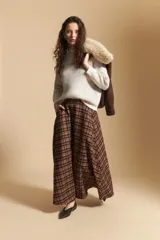 Falda larga de corte amplio y fluido con estampado de cuadros en tonos tierra. Presenta un diseño de tiro medio que aporta elegancia y comodidad.