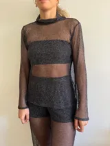 Polera de red negra con cuello alto y mangas largas.