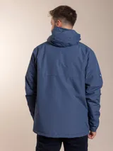 Campera negra con capucha, cierre frontal con cremallera y bolsillos laterales con botón a presión.