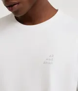 Remera de algodón de corte comfort, con cuello redondo y manga corta. Presenta un pequeño estampado de lettering localizado en el pecho con la frase 'Aire, Mar, Amar'.