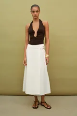 Body de cuello halter con espalda descubierta, confeccionado en poliamida. Presenta un diseño drapeado en los laterales y una abertura frontal con detalle metálico. Posee cierre con botones a presión en la parte inferior y lazada en el cuello.