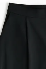 Pantalón ancho de punto color negro, de tiro alto con elástico oculto en la cintura, piernas amplias con pinzas y bolsillos al bies.
