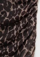Vestido midi de tirantes finos con estampado animal print de leopardo. Presenta un diseño entallado con fruncidos laterales y cuello escotado.