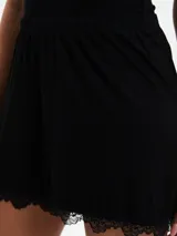 Short de pijama gris melange con cintura elástica y detalle de encaje blanco en el ruedo.