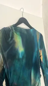 Vestido midi de lycra con estampado abstracto en tonos azul, verde y amarillo, de mangas largas y cuello redondo.