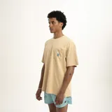 Remera celeste de corte holgado con bolsillo en el pecho y logo estampado en color naranja.