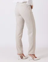 Pantalón sastrero de corte slim, color blanco, con pretina anatómica y panel interno modelador. Presenta bolsillos laterales tipo ojal, bolsillos traseros simulados y nervadura vertical marcada en el frente.