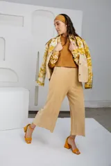 Pantalón capri color beige, de tejido acanalado, con cintura elástica y bolsillos laterales.