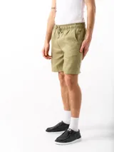 Shorts color verde oliva confeccionados en lino, con cintura elástica ajustable con cordón, dos bolsillos laterales y un bolsillo trasero.