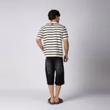 Bermuda de jean baggy color negro con lavado gastado, de corte ancho y largo hasta debajo de la rodilla, con diseño de cinco bolsillos y detalles de recortes en los bolsillos traseros.