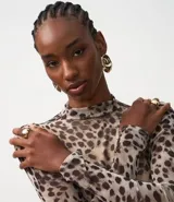 Blusa de tule con estampado animal print, de manga larga y cuello alto.