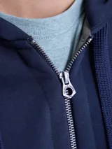 Canguro con cierre frontal completo, confeccionado en tejido fleece de color azul marino. Presenta capucha con cordones ajustables, bolsillos laterales y puños y ruedo acanalados.