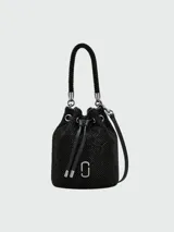 Cartera tipo bucket bag de Marc Jacobs, confeccionada en material negro con acabado brillante de strass. Presenta cierre de cordón ajustable, asa superior trenzada y correa de hombro extraíble. Incluye logo metálico plateado en el frente.
