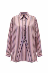 Camisa de corte oversize con diseño de rayas verticales en tonos rosado, azul y marrón. Presenta cuello clásico, cierre frontal con botones y un detalle distintivo de ribete en zigzag oscuro que recorre la abertura frontal.
