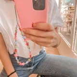 Llavero para celular con cuentas de colores en forma de estrella y cuentas plateadas.